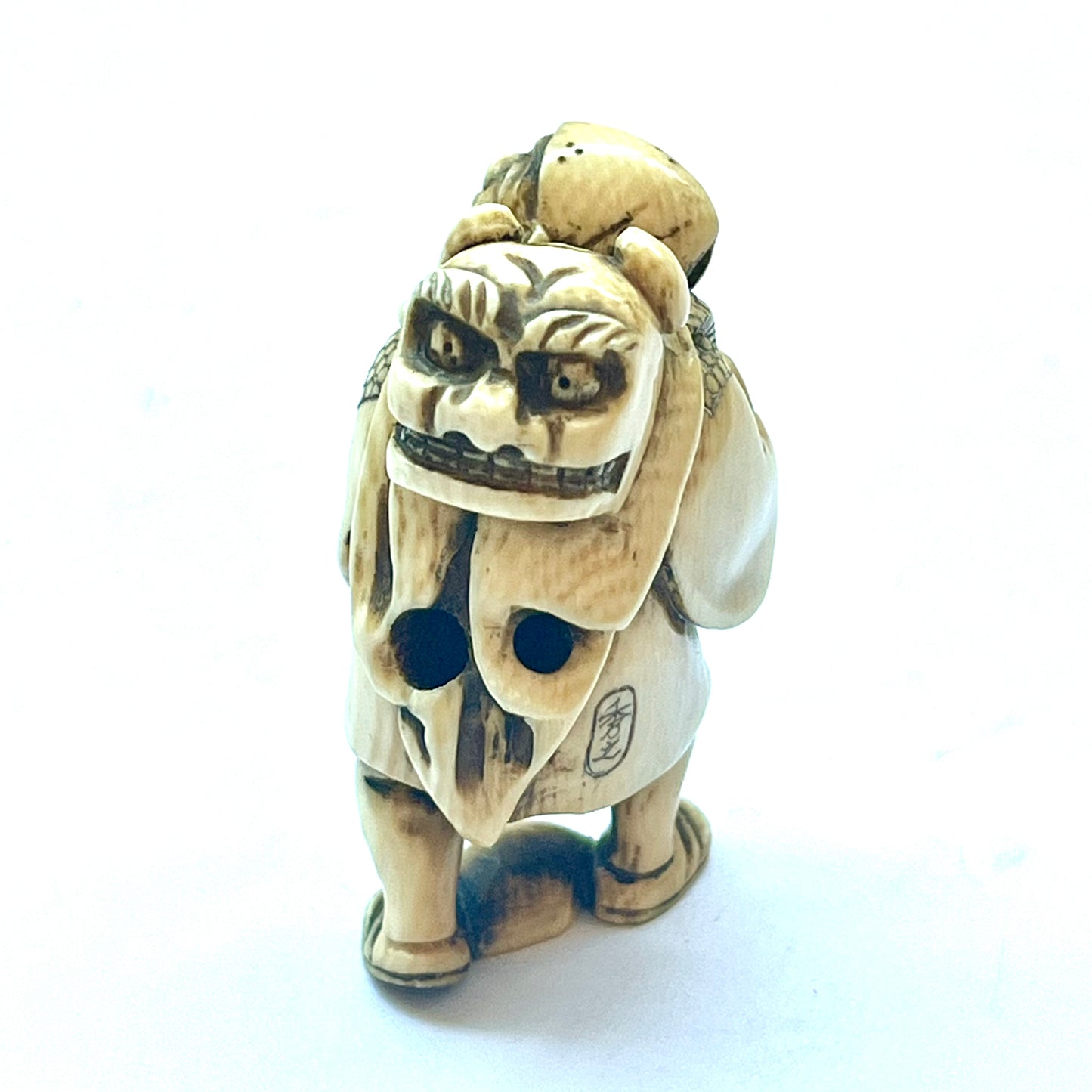 Antique Japanese Meiji Period ivory netsuke depicting an old man carrying a shishi, signed by Hideyuki