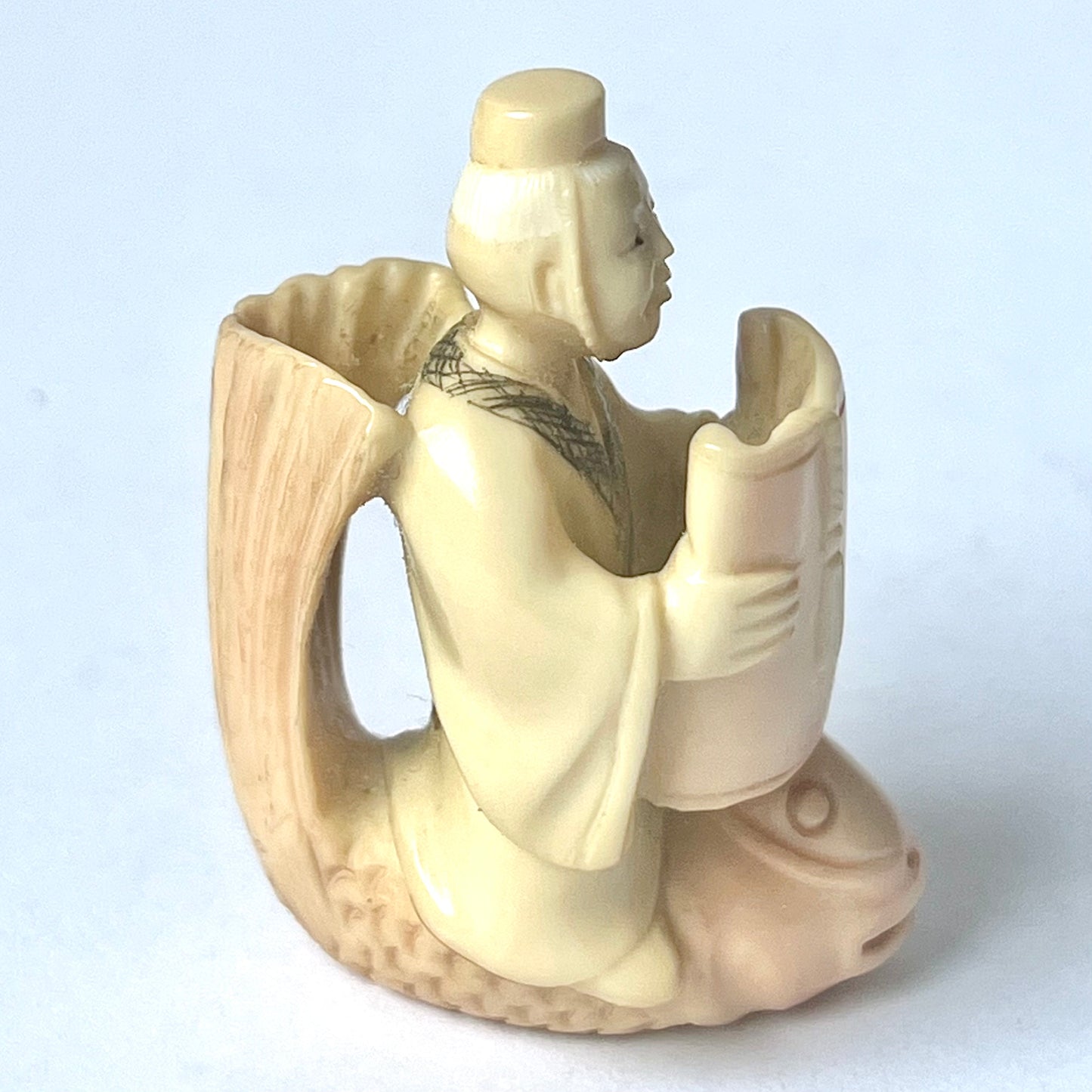 Antique Japanese ivory netsuke of the Taoist immortal Kinko riding on a red carp