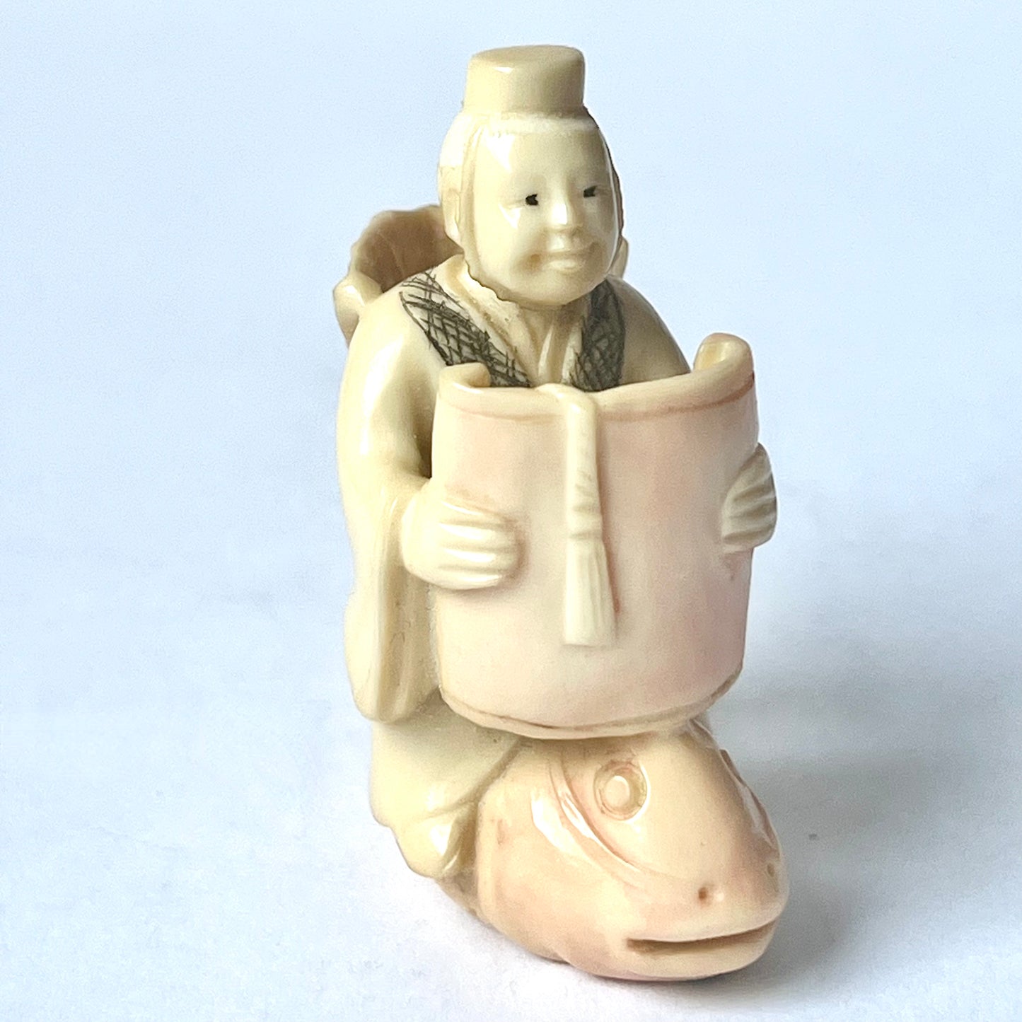 Antique Japanese ivory netsuke of the Taoist immortal Kinko riding on a red carp