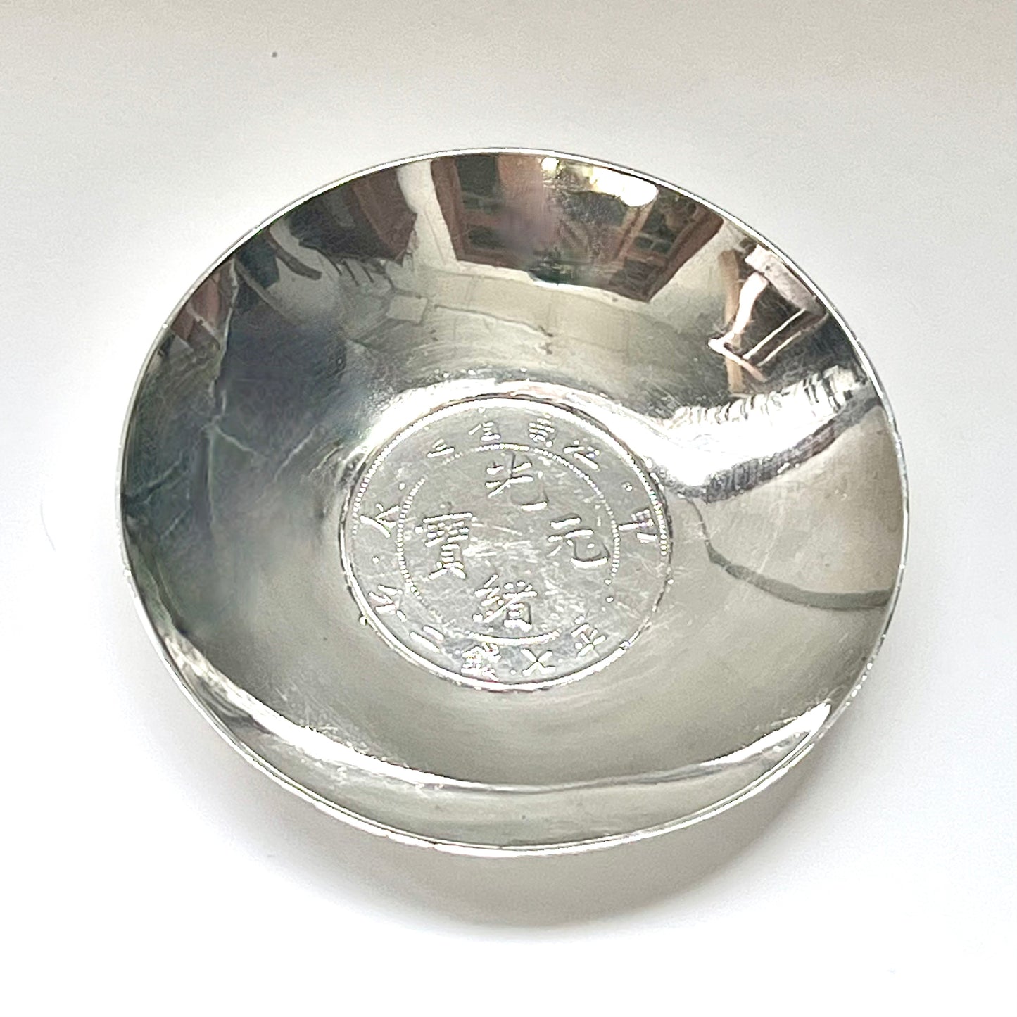 Plato de baratijas de plata de exportación china, con una rara moneda Jiang nan (Kiang Nan) de 7 Macis y 2 Candareen en su base, del período Guangxu, circa 1898-1905.