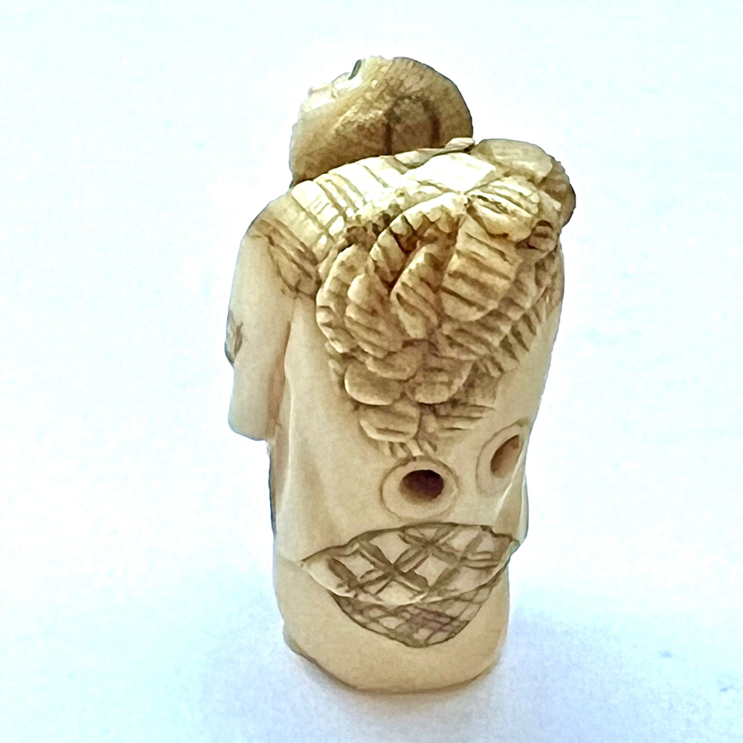 Antique Japanese Meiji Period ivory netsuke depicting an old lady carrying bundles. Signed by 玉之 (Gyokuyuki)