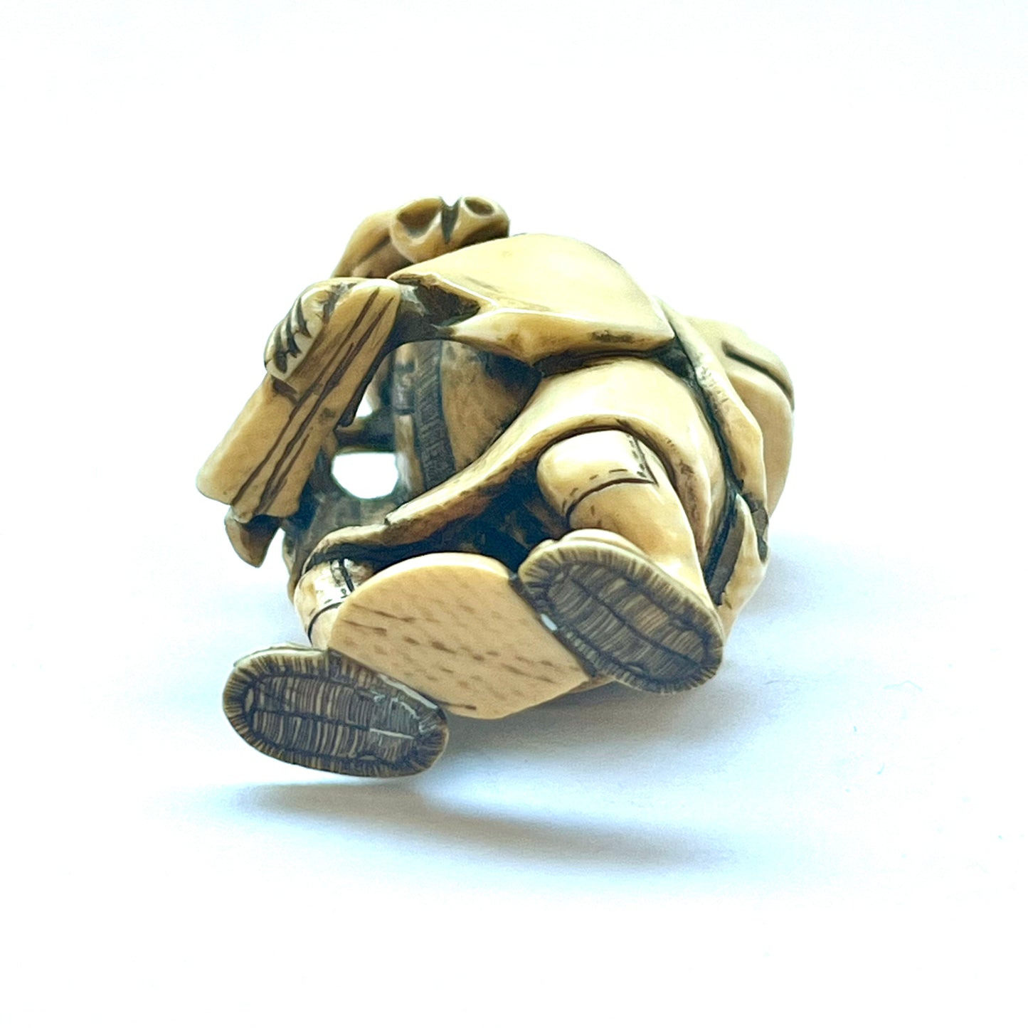 Antique Japanese Meiji Period ivory netsuke depicting an old man carrying a shishi, signed by Hideyuki