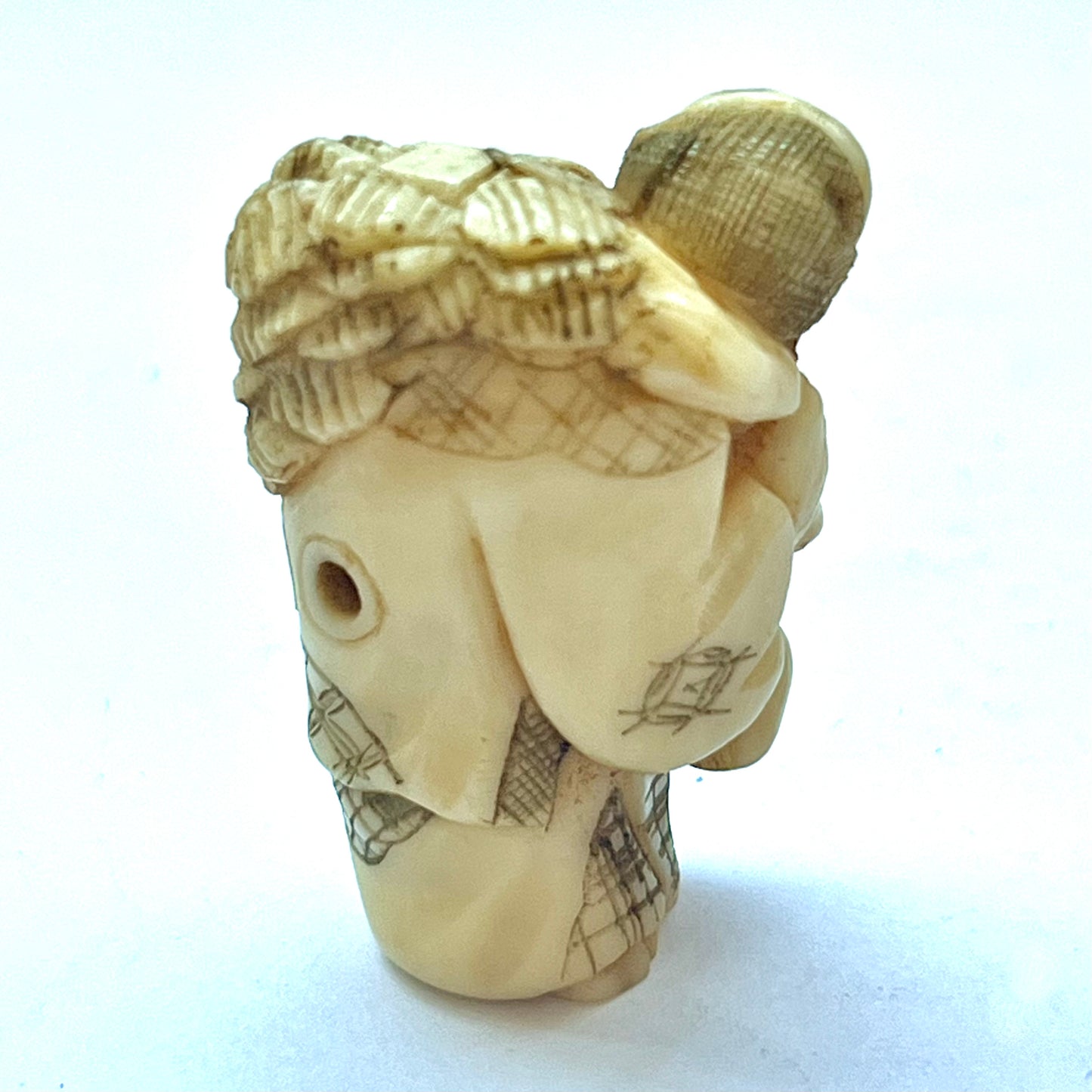 Antique Japanese Meiji Period ivory netsuke depicting an old lady carrying bundles. Signed by 玉之 (Gyokuyuki)