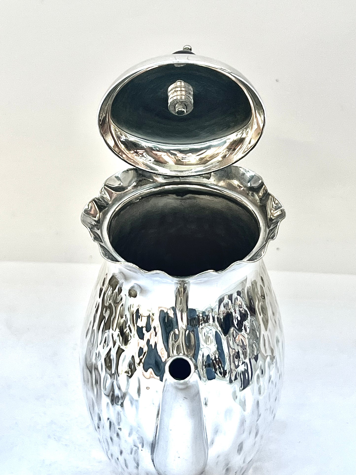 Antiguo juego de té de soltero bañado en plata, circa 1900, compuesto por una pequeña tetera, una jarra para leche, un azucarero y una taza de té.