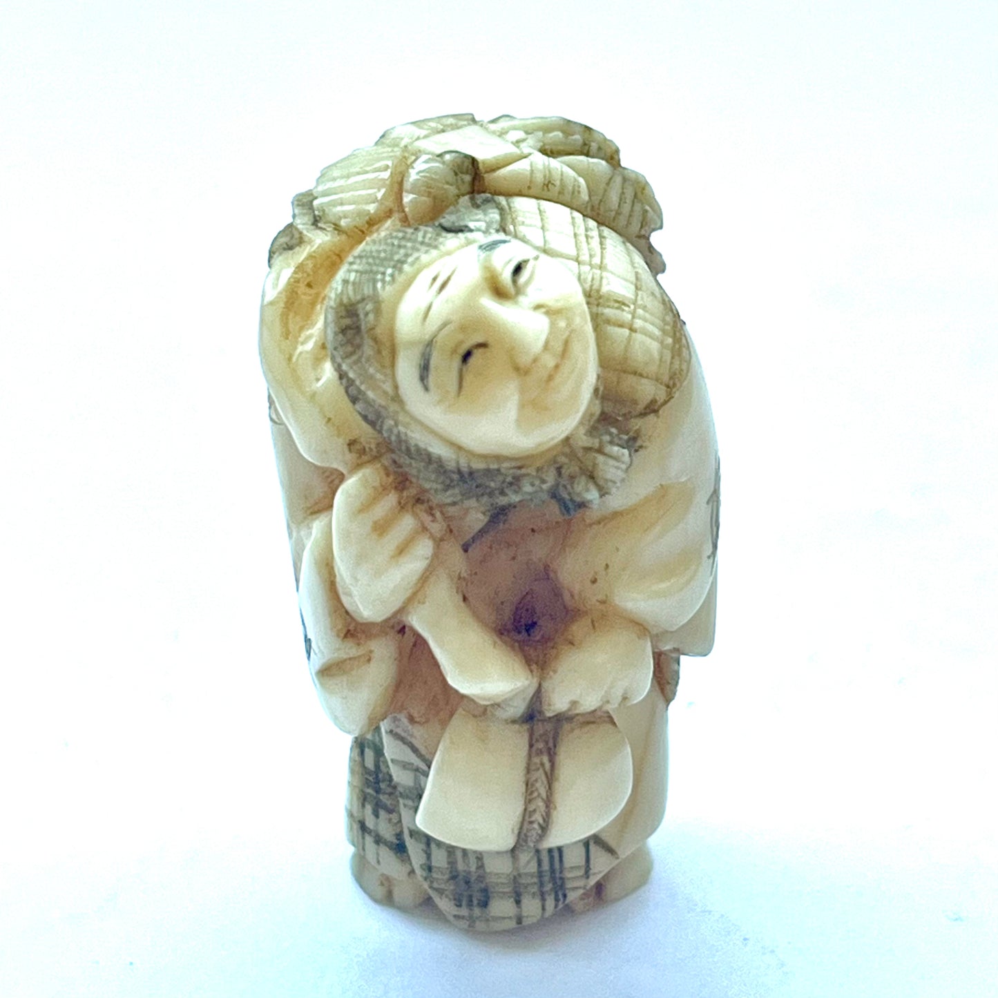 Antique Japanese Meiji Period ivory netsuke depicting an old lady carrying bundles. Signed by 玉之 (Gyokuyuki)