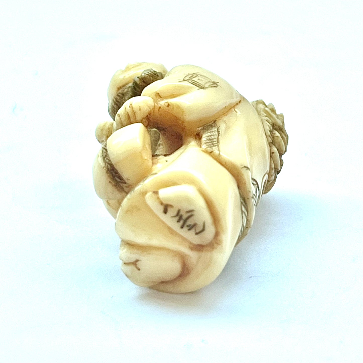 Antique Japanese Meiji Period ivory netsuke depicting an old lady carrying bundles. Signed by 玉之 (Gyokuyuki)
