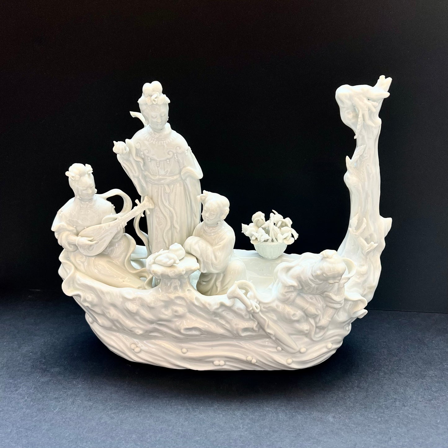Grupo figurativo de porcelana Dehua Blanc de Chine del siglo XIX que representa a cuatro doncellas celestiales o inmortales femeninas que cabalgan sobre una barca con forma de árbol.
