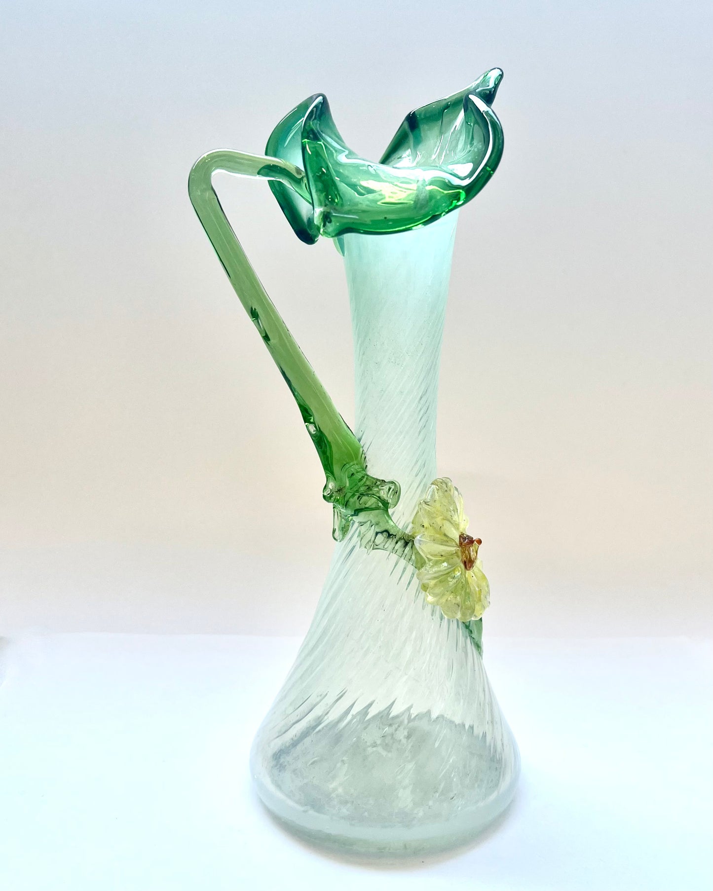 Antiguo jarrón de cristal verde y opalescente con forma de gato en el púlpito, con decoraciones florales de vidrio aplicadas, probablemente checoslovaco.