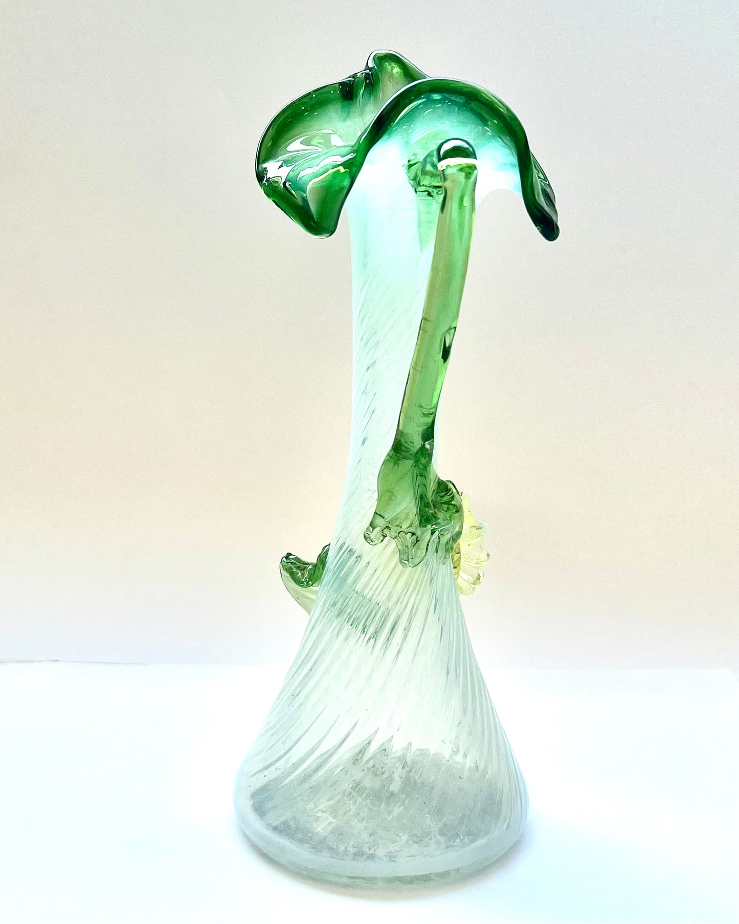 Antiguo jarrón de cristal verde y opalescente con forma de gato en el púlpito, con decoraciones florales de vidrio aplicadas, probablemente checoslovaco.