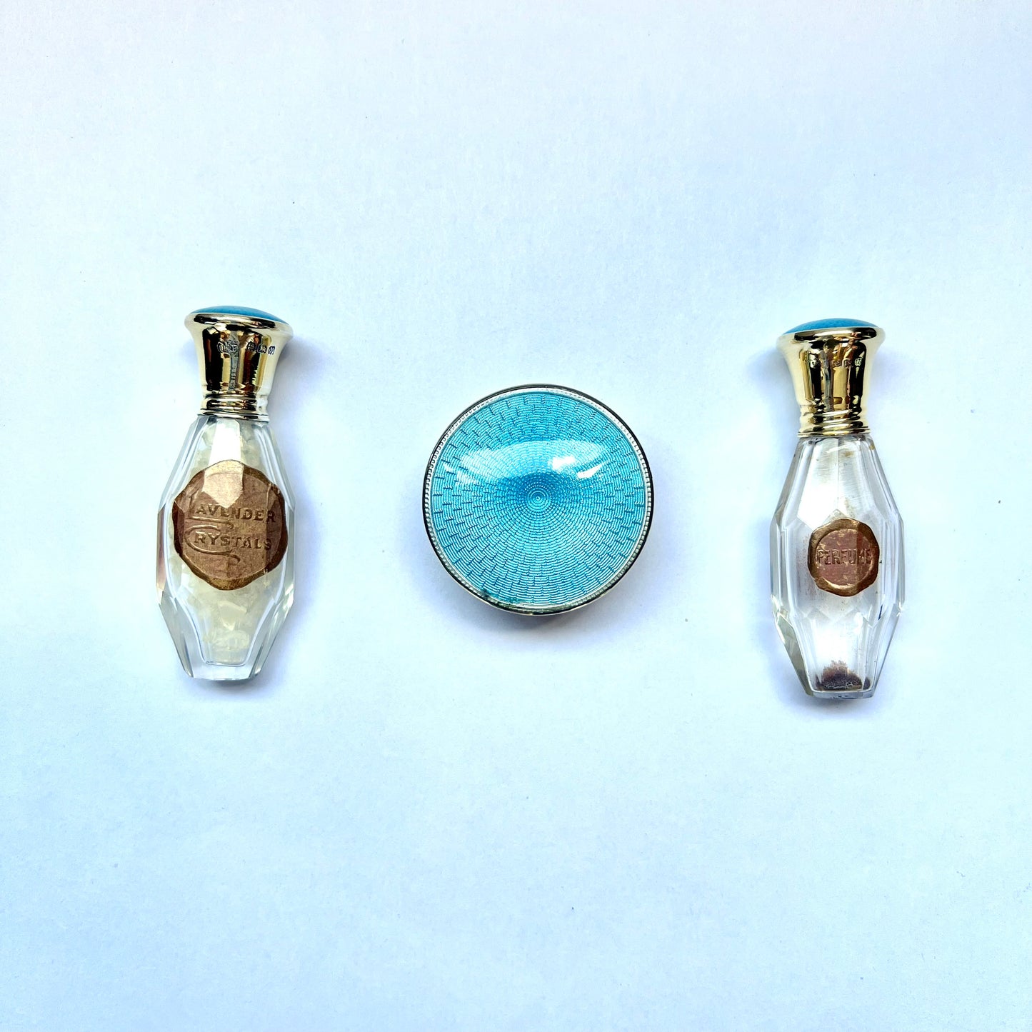Antiguo neceser de viaje Art Déco con esmalte guilloché azul verdoso y dorado sobre plata de ley. Cristales de lavanda, frasco de perfume y borla de polvos sueltos.