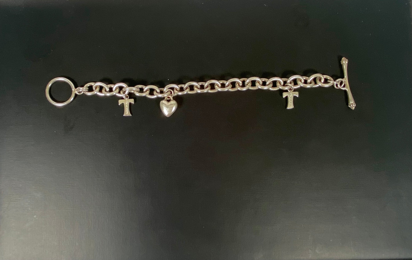 Vintage unmarked charm bracelet, tests silver, w 3 Tiffany & Co. hallmarked sterling silver charms