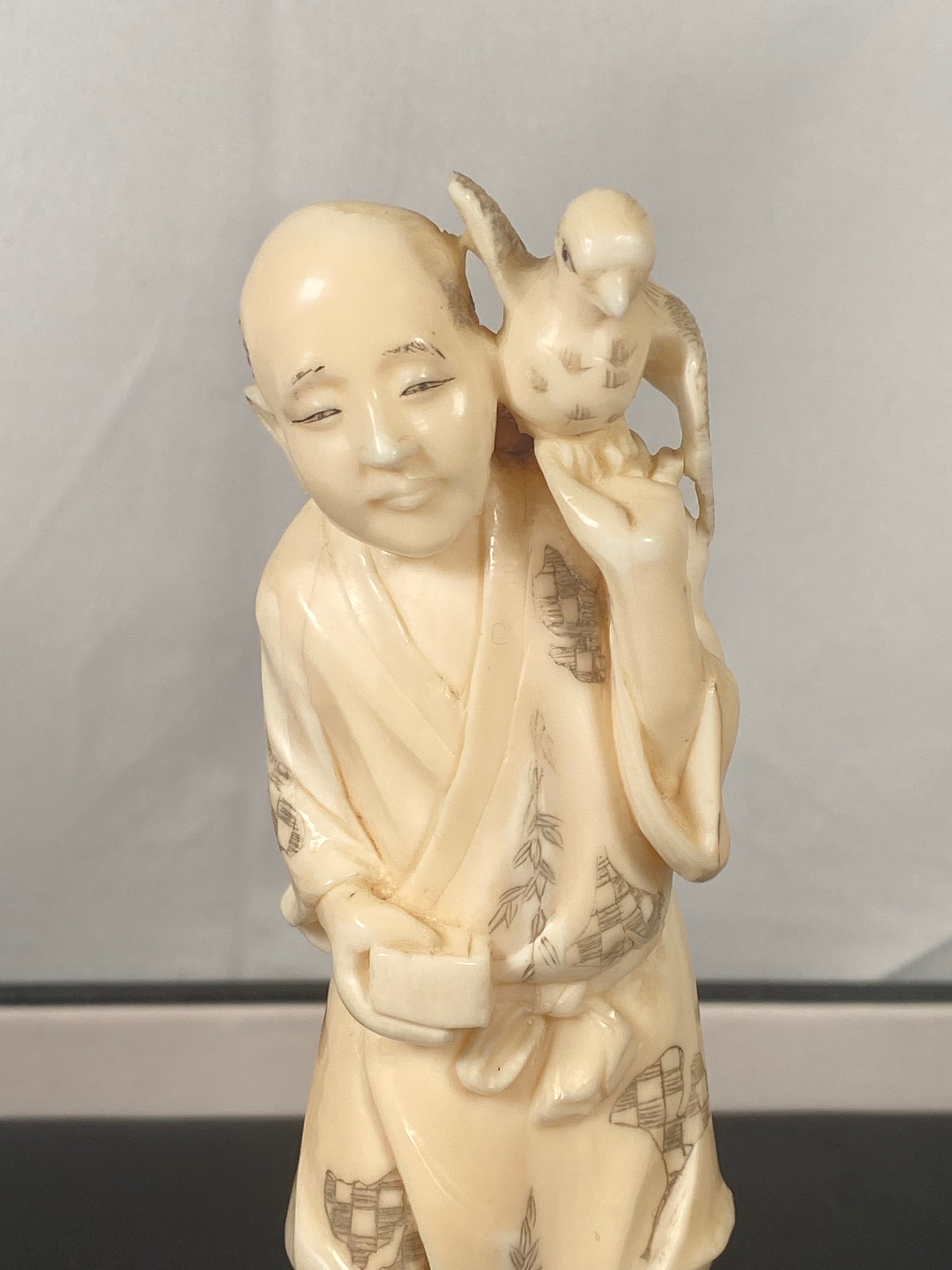 Okimono japonés antiguo de marfil de un cetrero, firmado por Ouichi