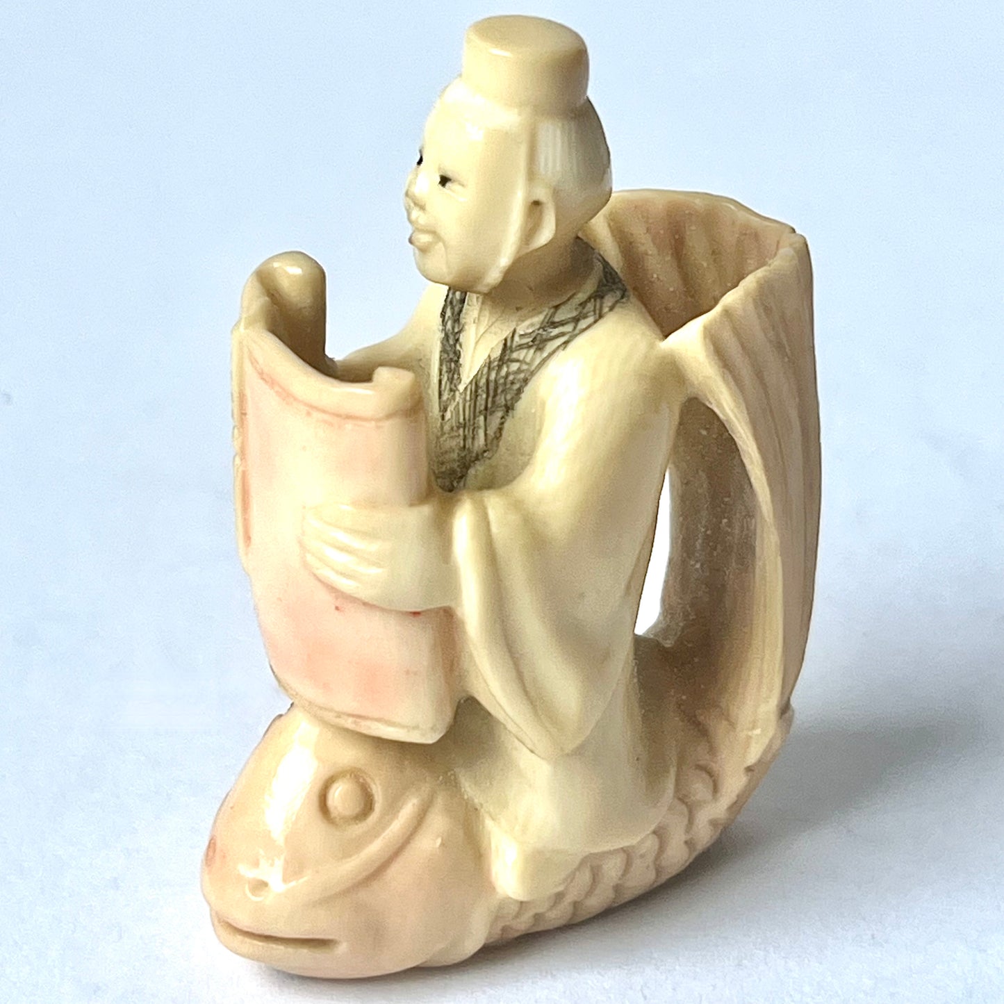 Antique Japanese ivory netsuke of the Taoist immortal Kinko riding on a red carp