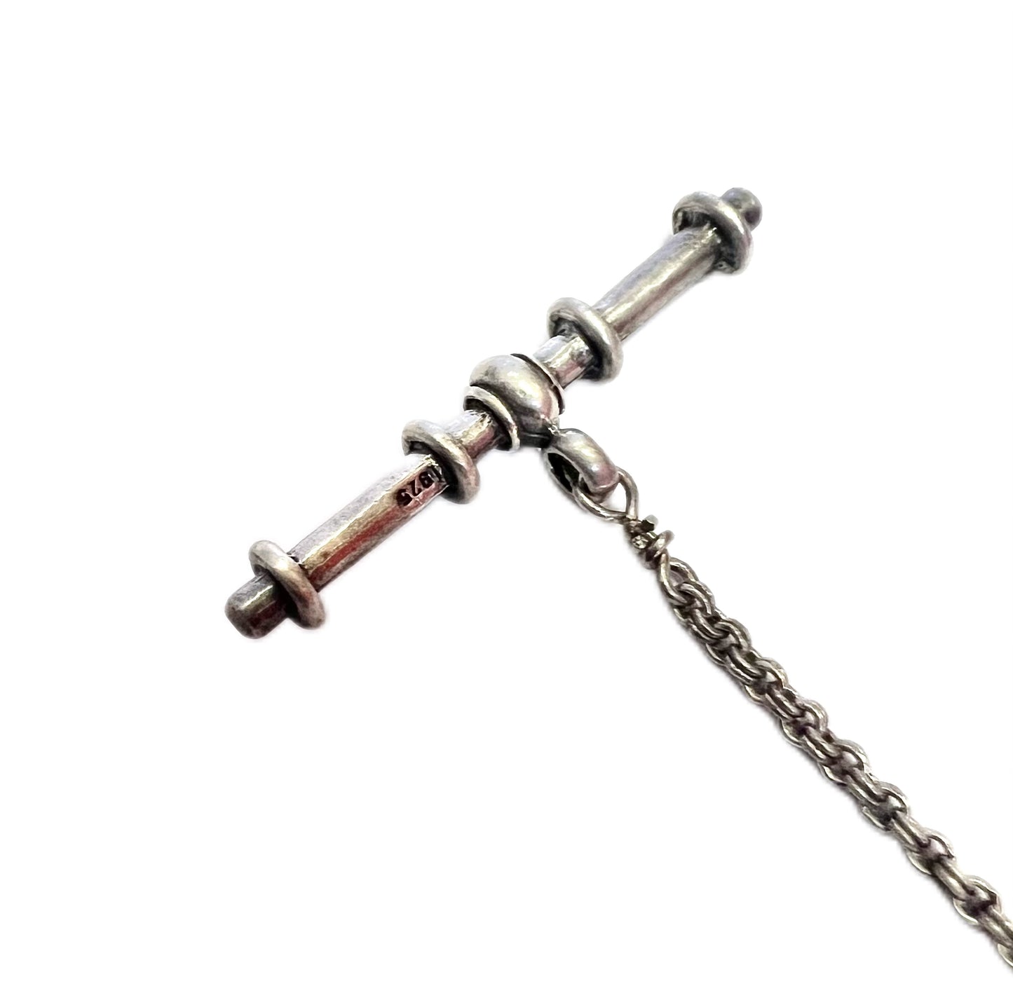 Rose quartz charm suspended from a sterling silver chain with T-bar