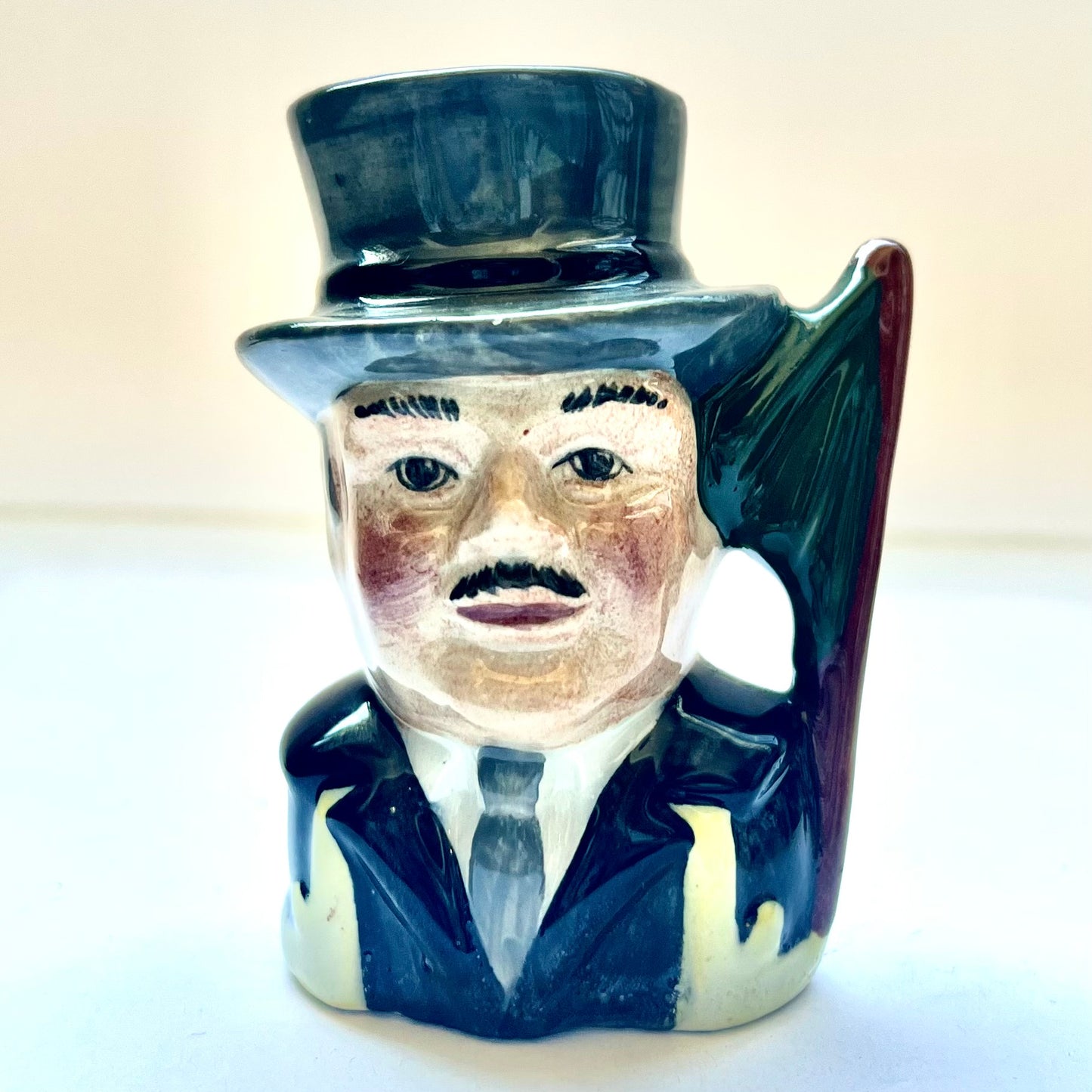 Vintage toby jug of a gentleman in top har, holding an umbrella